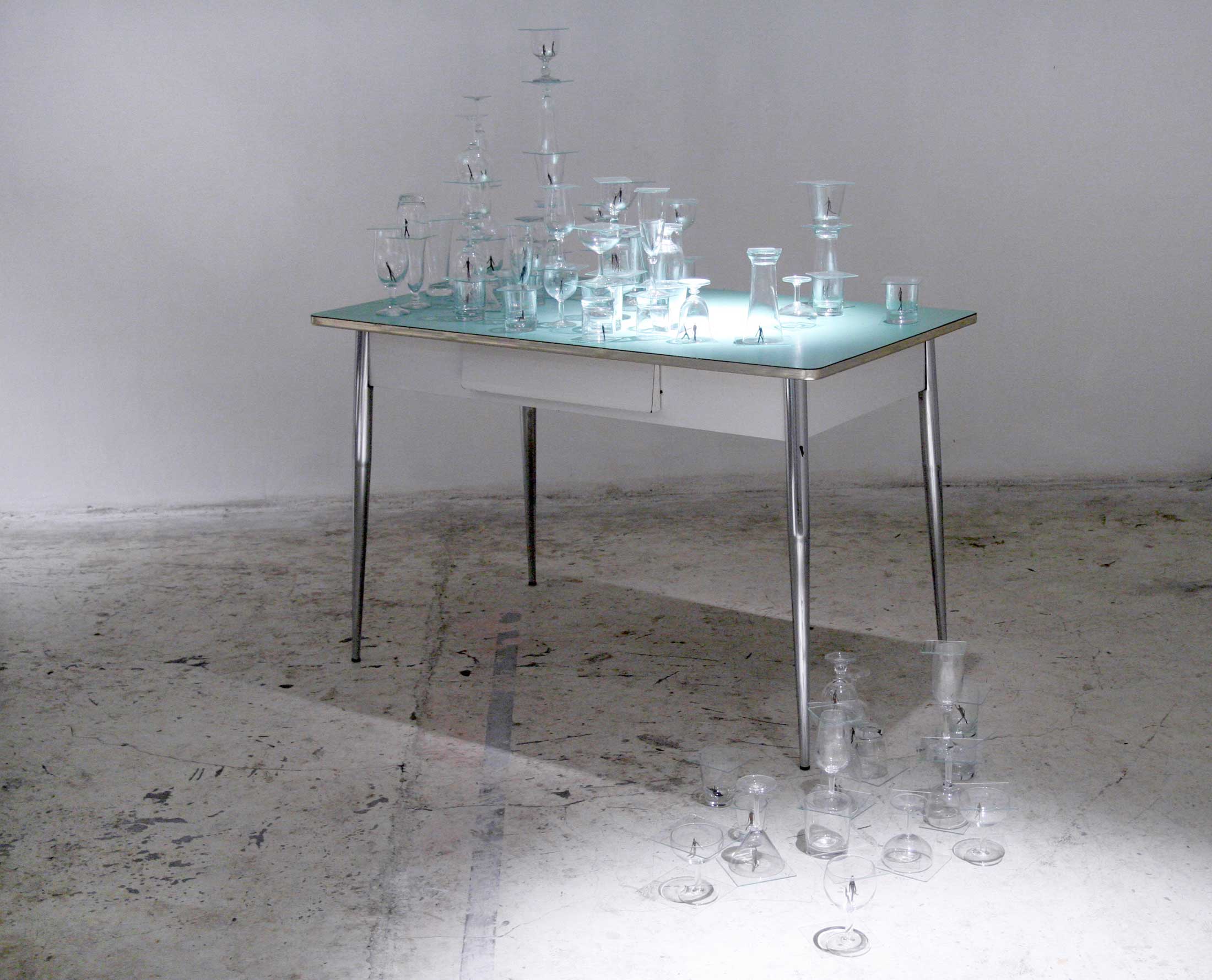 SIAMO COME LE CIMICI (We are like bedbugs)_ 2003 Glasses, wood men, kitchen green ant table cm 125 x 73 x 120. Ph Elio Colavolpe